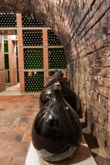 Wine cellar with bottles and demijohns