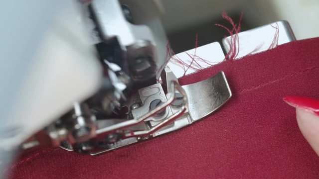 Shooting of tailor woman sewing order on electric overlock