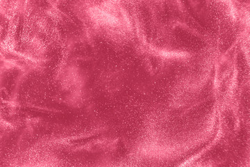 Abstract elegant, detailed pink glitter particles flow with shallow depth of field underwater....