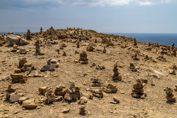 Many stacked stones on a hill at peninsula Prasonisi on Rhodes island, Greece