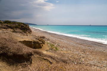 Fototapeta na wymiar Gravel / pebble beach at the westcoast of Rhodes island near Kattavia with ocean waves