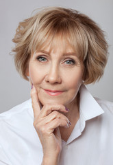 Portrait of a beautiful elderly happy blonde woman with beautiful nude make-up, with clean skin in...