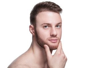 Obraz premium Portrait of a handsome man, with a shaved beard and mustache, and trimmed hair on white background. Cosmetology concept