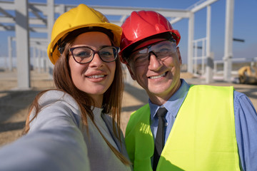 Mature Businessman and Female Architect Taking Selfie Photo with Cell Phone at Construction Site