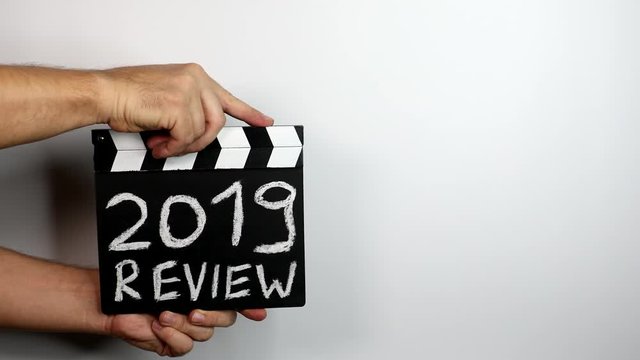 2019 review. Goals, survey and achievements concepts. hands holding movie clapper