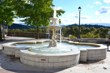 sunny day and splashes of water in the fountain on the Deportation Square in Po against the backdrop of the Pyrenees