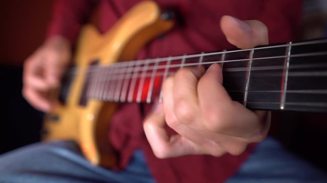 Close up of human hand is playing guitar