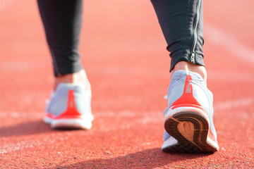 close up view of an athlete getting ready for the race on a running track . Focus on shoe of an athlete about to start a race in stadium .