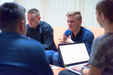 Group of a young business people brainstorming and discussing business plan on meeting at sunny bright office interior.
