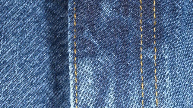 Closed fly on a pair of jeans, tracking. Close up top view. Slider shot. 4K 422 10 bit