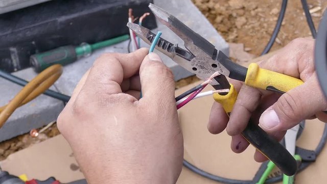 Technician strips and prepares wires for connection - close-up HD