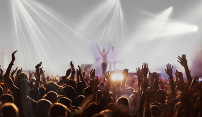 crowd with raised hands at concert festival banner