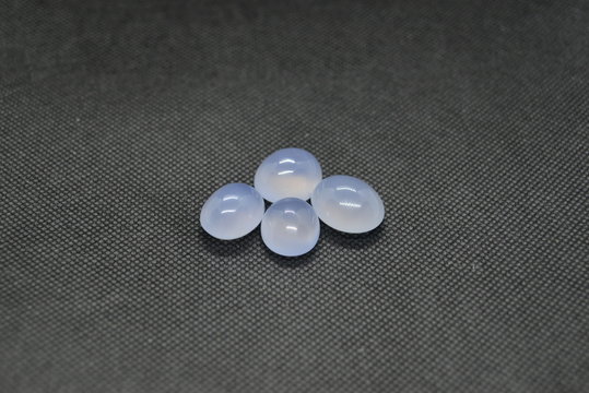 Natural Chalcedony in a shape of cobochon on black fabric background.