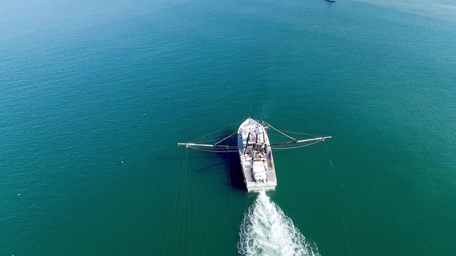 A White Trawling Shrimp Boat on the Water, Aerial Circling Point of Interest Shot