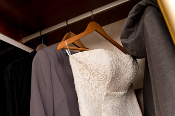 bridesmaid dress hanging in a closet among casual clothes