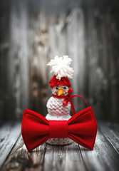 Christmas decoration in vintage toning on dark black wooden background with knitting red bowtie. Xmas decorative ornaments for design. Art work texture holiday new year 2020