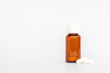 white pills with brown glass supplement medicine isolated on white background 