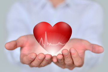 The close-up businessman holds a 3D red heart, a concept of health, medicine, people and heart disease.