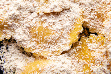 Tasty raw ravioli with flour and basil on wood table