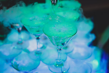 Beautiful tower line of different colored alcohol cocktails wit on a party event, tequila, martini, vodka, and others on decorated catering banquet table