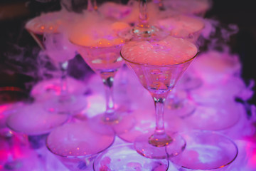 Beautiful tower line of different colored alcohol cocktails wit on a party event, tequila, martini, vodka, and others on decorated catering banquet table