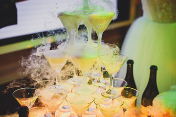Beautiful tower line of different colored alcohol cocktails wit on a party event, tequila, martini, vodka, and others on decorated catering banquet table