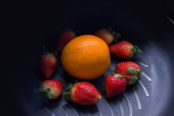 Fototapeta na wymiar Few strawberries and oranges.