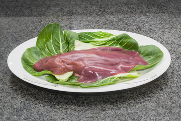Fresh liver is served on a white China plate