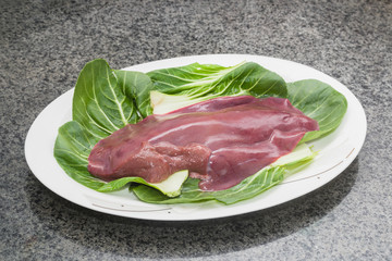 Fresh liver is served on a white China plate