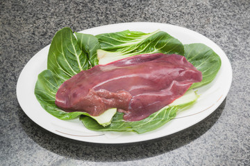 Fresh liver is served on a white China plate