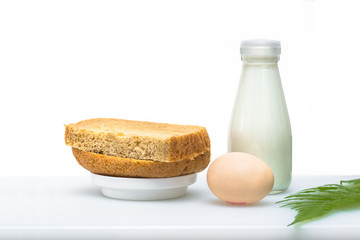 A nutritious breakfast of bread and eggs with milk, garnished with a green leaf.
