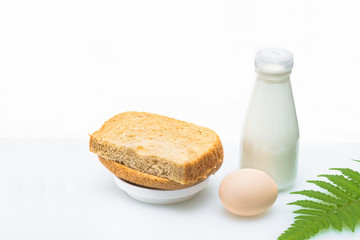 A nutritious breakfast of bread and eggs with milk, garnished with a green leaf.
