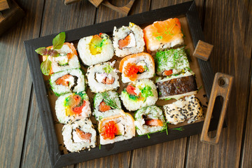 Traditional japanese food on a dark wooden background. Sushi rolls. Asian food frame. Dinner party. Top view image
