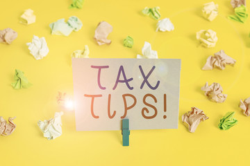 Conceptual hand writing showing Tax Tips. Concept meaning compulsory contribution to state revenue levied by government Colored crumpled paper empty reminder white floor clothespin