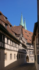 Towers of the Bamberg cathedral peeking out behind typical medieval buildings.