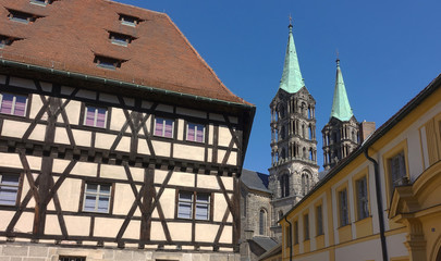 Towers of the Bamberg cathedral peeking out behind typical medieval buildings.