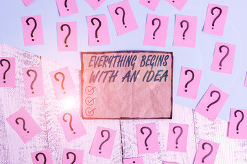 Writing note showing Everything Begins With An Idea. Business concept for steps you take to turn an idea into a reality Scribbled and crumbling papers with thick cardboard above wooden table