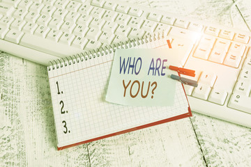 Handwriting text Who Are You Question. Conceptual photo asking about someone identity or demonstratingal information notebook paper reminder clothespin pinned sheet white keyboard light wooden