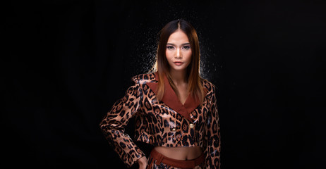 Portrait half body of Young Asian Woman Tan skin high fashion wears Snake Skin Pattern dress, spin head throw hair. Studio Lighting Black Background isolated copy space, backlit light with effect fog