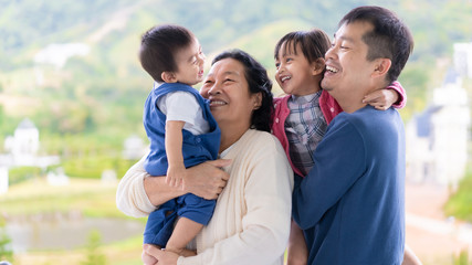 Happy asian family with multi generation people are playing with the baby and smiling together with happiness moment, concept of trustness love and relation in asian family lifestyle.