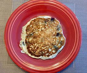 Blueberry pancake on red plate for breakfast on table