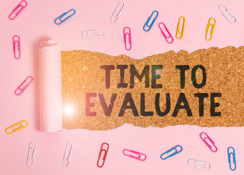 Conceptual hand writing showing Time To Evaluate. Concept meaning judge something with respect to its worth or significance Paper clip and torn cardboard on wood classic table backdrop