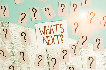 Word writing text What S Next Question. Business photo showcasing asking demonstrating about his coming actions or behaviors Scribbled and crumbling papers with thick cardboard above wooden table