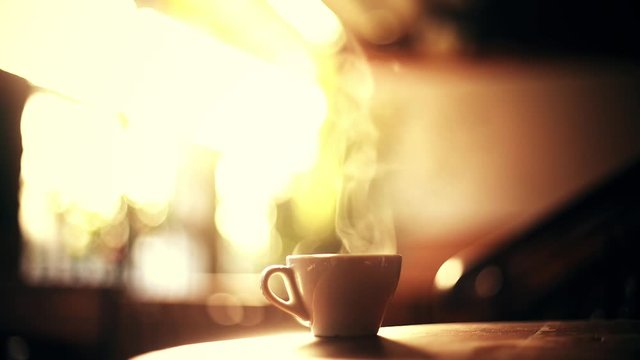 Close up shot of a hot coffee cup with steam coming out of it, in a morning, in Bucharest, Romania.