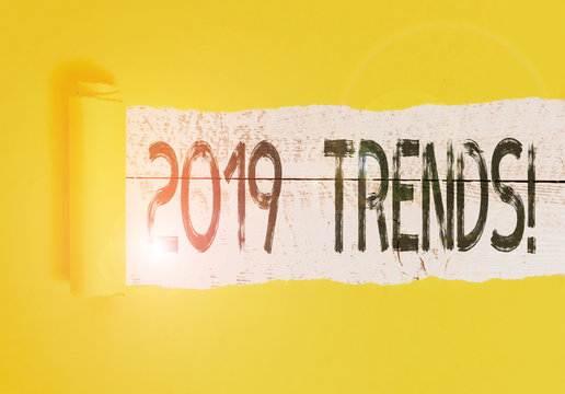 Text sign showing 2019 Trends. Business photo text general direction in which something is developing or changing Cardboard which is torn in the middle placed above a wooden classic table