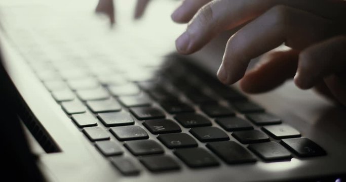 Close up 4K footage of a woman typing at a laptop keyboard.