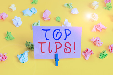 Conceptual hand writing showing Top Tips. Concept meaning small but particularly useful piece of practical advice Colored crumpled paper empty reminder white floor clothespin