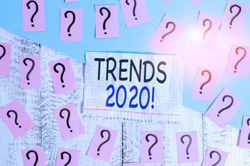 Conceptual hand writing showing Trends 2020. Concept meaning general direction in which something is developing or changing Crumbling papers with thick cardboard on the wooden table