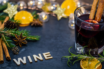 Be merry and red spiced wine winter holiday still life concept on dark slate board with dried oranges, anise stars, cinnamon sticks and evergreen sprigs