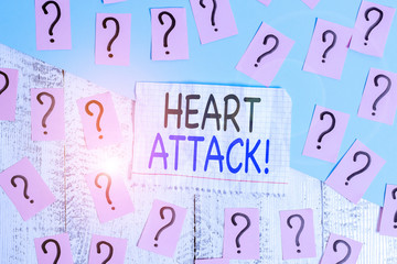 Conceptual hand writing showing Heart Attack. Concept meaning sudden occurrence of coronary thrombosis resulting in death Crumbling papers with thick cardboard on the wooden table